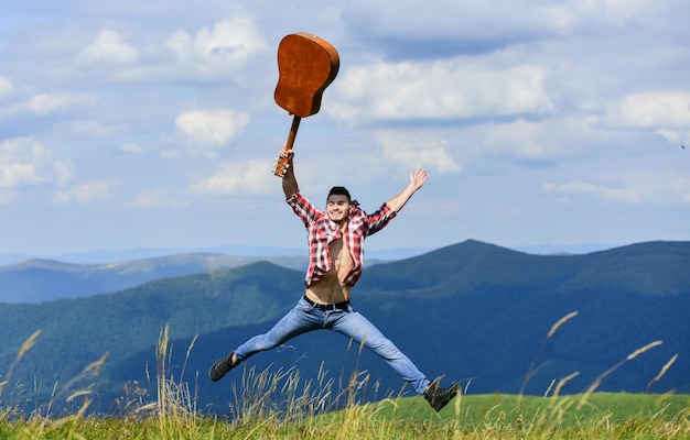 Cara caminhante desfruta da natureza pura Ar fresco da montanha Explorando a natureza Beleza da natureza Procurando inspiração Caminhando sozinho Homem com guitarra andando no topo da montanha Destinos de férias