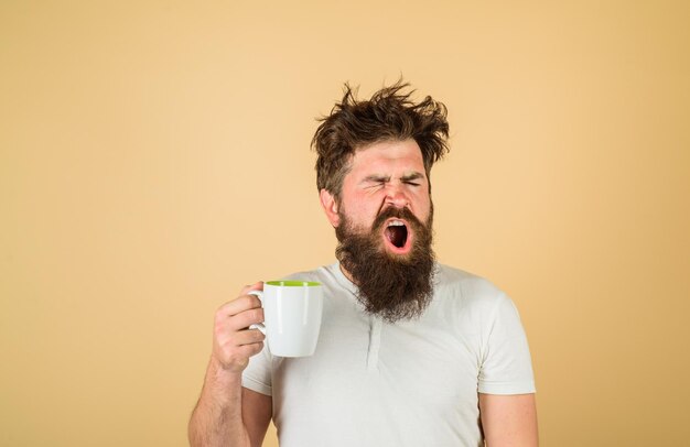 Cara cansado segura caneca de café refresco matinal homem sonolento segura xícara de café bocejando homem segura caneca