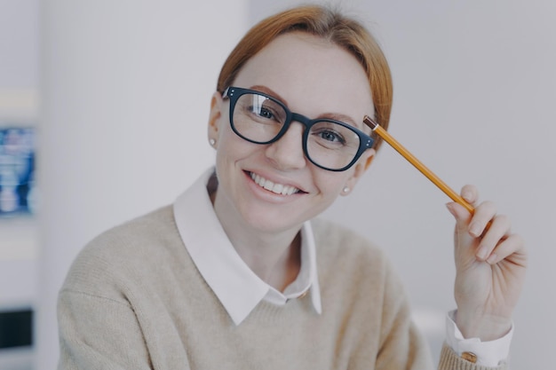 Cara de chica atractiva exitosa Estudiante feliz relajado sosteniendo lápiz y sonriendo Estudio remoto