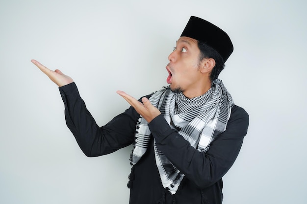 Cara chocada expressão homem muçulmano asiático vestindo turbante árabe sorban apontando dedo da mão