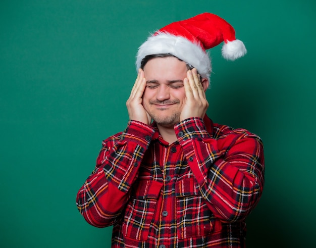 Cara com chapéu de Natal e camisa xadrez verde