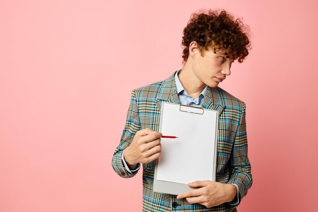 Cara com pasta de cabelo ruivo encaracolado para papéis folha em branco posando em terno isolado fundo inalterado