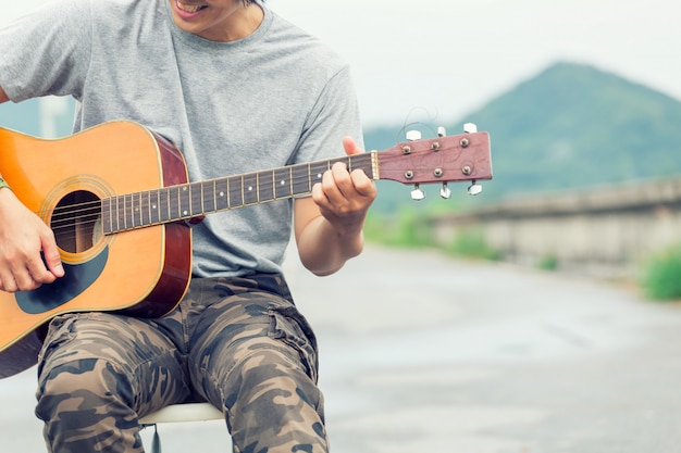 Cara com pé de guitarra na barragem, calças cargo