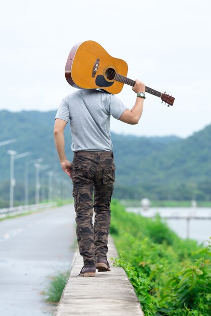 Cara com pé de guitarra na barragem