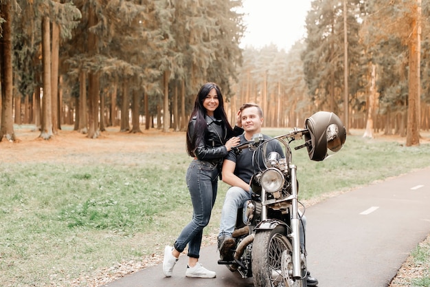 Cara com uma garota no parque em uma motocicleta