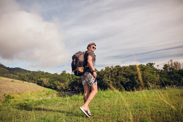 Cara com uma mochila no topo da trilha