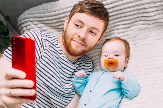 Cara, criança tira uma selfie na cama