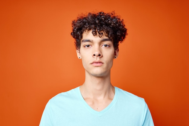 Cara de camiseta azul kiwi segurando fundo vermelho do estúdio de frutas