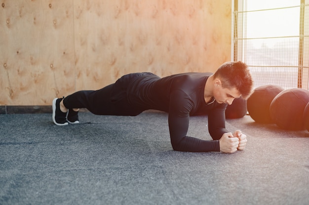 Cara de esportes fazendo exercício de prancha. academia e esportes. estilo de vida saudável.