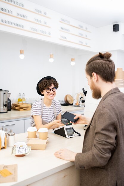 Cara de hipster pagando café usando smartphone