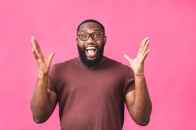 Cara de homem afro-americano chocado surpreso espantado em casual isolado sobre o retrato de estúdio de fundo rosa. Conceito de estilo de vida de pessoas. Simule o espaço da cópia. Manter a boca aberta.