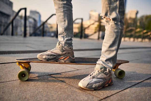 Cara de longboard na rua em uma bela noite de verão. Tons de cores quentes.