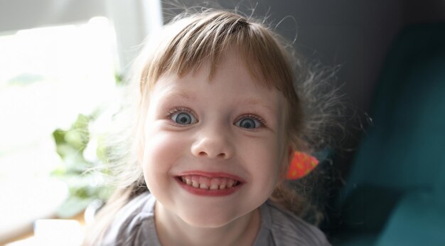 Foto cara de menina com olhos azuis. sorri de perto.