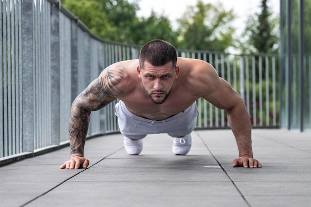 Cara em forma fazendo exercício na academia, homem bonito e esportivo treinando com halteres no atleta masculino wi