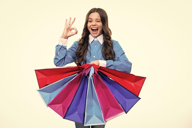 Cara emocionada Graciosa jovencita sostenga una bolsa de compras disfrutando de la venta aislada en blanco Retrato de una colegiala adolescente lista para ir de compras Expresión asombrada alegre y contenta