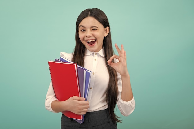 Cara emocionada Niña adolescente con libros Estudiante de escuela Expresión asombrada alegre y contenta