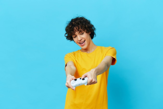 Cara encaracolado brinca com joystick em fundos isolados de camisetas amarelas