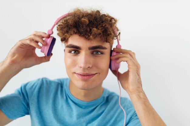 Cara excêntrico em camiseta azul fones de ouvido rosa moda fundo claro