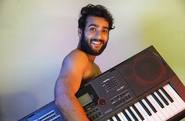 Foto cara feliz com piano eletrônico