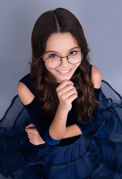 Cara feliz emociones positivas y sonrientes de niña adolescente Retrato emocional de niña adolescente caucásica aislada sobre fondo gris de estudio