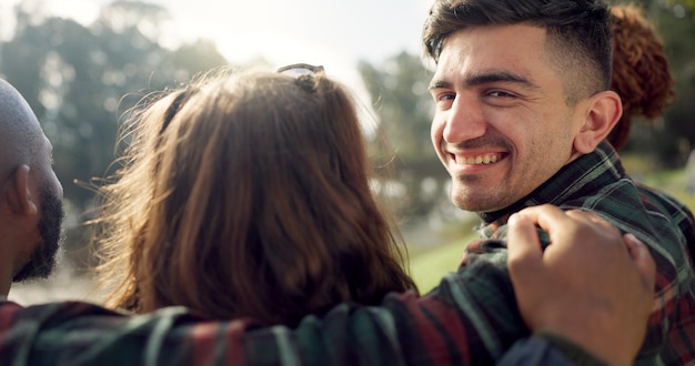 Cara feliz y hombre con amigos en el lago acampando en la naturaleza o en grupo riendo y uniéndose en un picnic al aire libre en el parque Retrato de persona o sonrisa en conversación reunión social o relajarse en el bosque