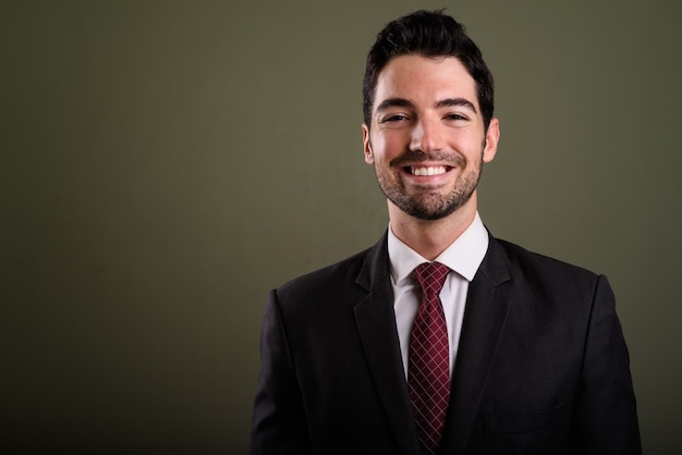 Cara de feliz joven empresario guapo en traje sonriendo