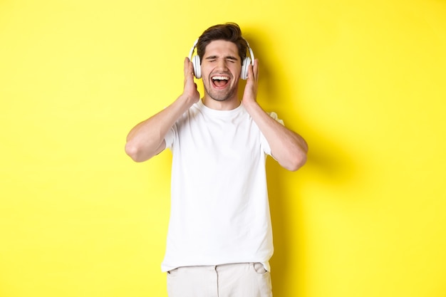 Cara feliz ouvindo música em novos fones de ouvido