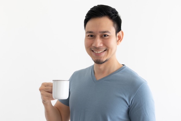 La cara feliz de la sonrisa del hombre asiático bebe café en el espacio aislado.