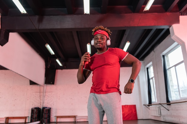 Cara flexível e bonito trabalhando duro no estúdio de dança enquanto cria movimentos e dança