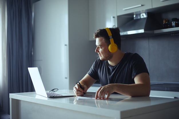 Cara focado usando fones de ouvido, ouvindo música enquanto planeja o dia de trabalho