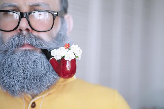 Cara fumando cachimbo. Hipster com barba grisalha e bigode. Conceito de maus hábitos