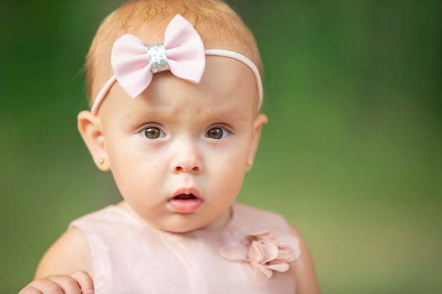 La cara de una hermosa niña sobre un fondo verde Niño de un año