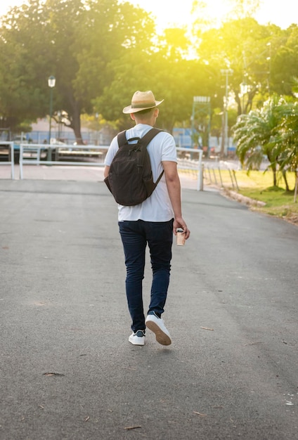 Foto cara hipster andando na rua viajante cara andando na cidade homem atraente de chapéu andando na rua