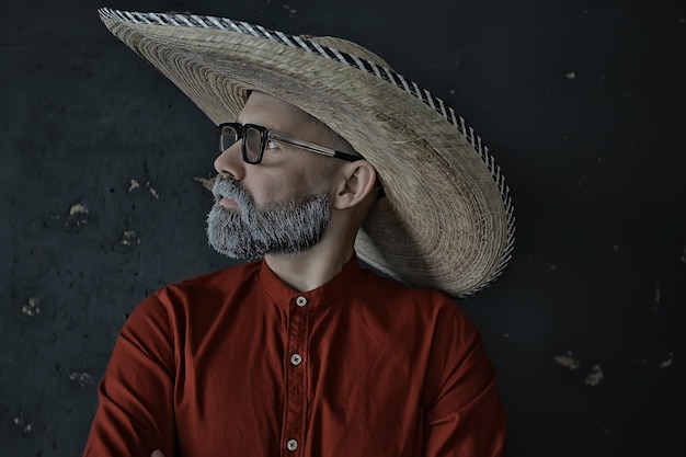 Foto cara hipster de óculos com uma barba grisalha em um chapéu com aba. homem modelo emocionalmente posando