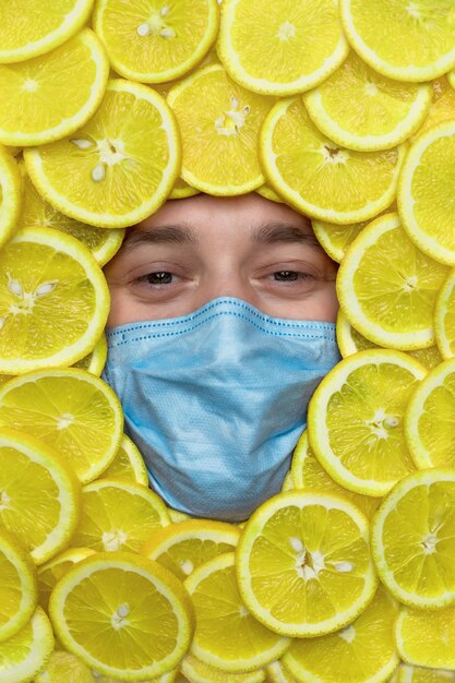 la cara de un hombre con limones con una máscara médica. La vitamina C es una cura para el resfriado común. hombre enmascarado