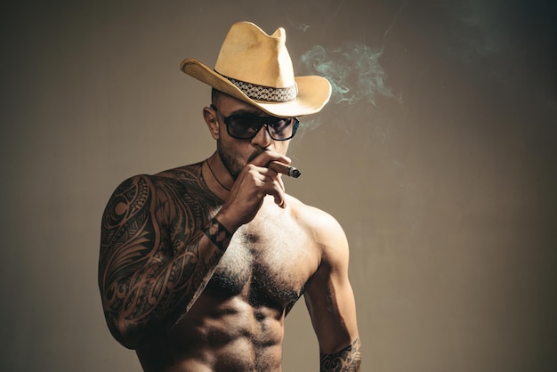 Cara de hombre sexy imponente chico en gafas fumando cigarro para hombre belleza retrato de moda