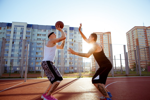 Cara jogando basquete em uma quadra vermelha