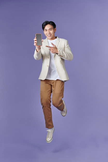 Cara jovem animado pulando dedo indicador no celular com tela vazia em branco