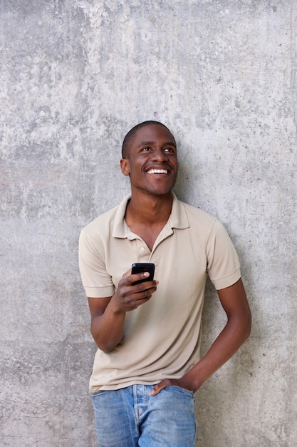 cara jovem bonito rindo com telefone móvel