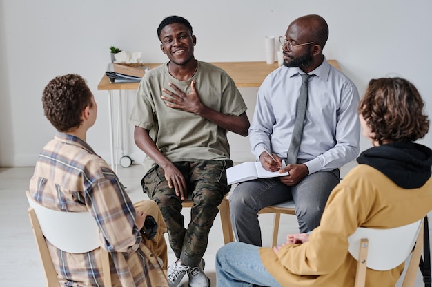 Cara jovem feliz visitando a aula de terapia