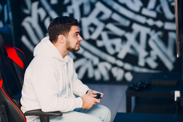 Jovem adulto jogando estratégia de videogame em casa, se