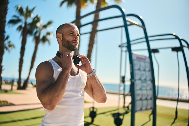 Foto cara jovem se exercitando com treino de calistenia em uma academia ao ar livre