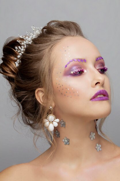 Cara de modelo con maquillaje púrpura Belleza con cejas inusuales Retrato de niña hermosa