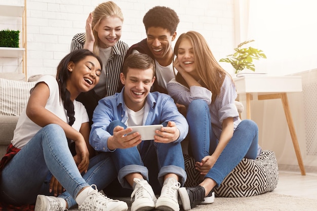 Cara mostrando vídeo no telefone para amigos