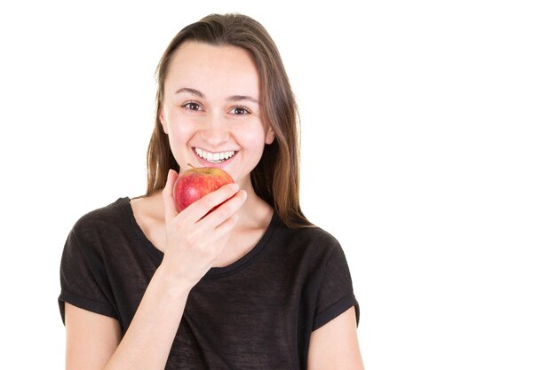 Cara de mujer joven con manzana roja mira cámara en espacio de copia de fondo blanco