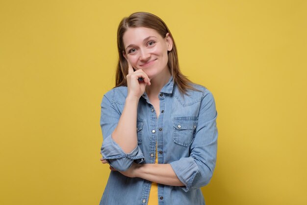 Cara de mujer sonriente de belleza retrato de cerca en la pared amarilla