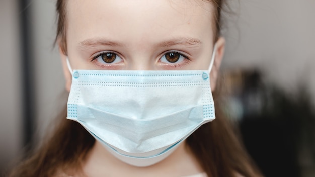Cara de niña en máscara médica respiratoria de cerca