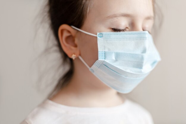 Cara de niña en primer plano de máscara médica respiratoria