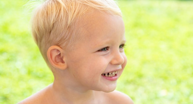 Cara de niños lindos Retrato de primer plano de niño sonriente sobre fondo verde Concepto de emoción de sonrisa de niño