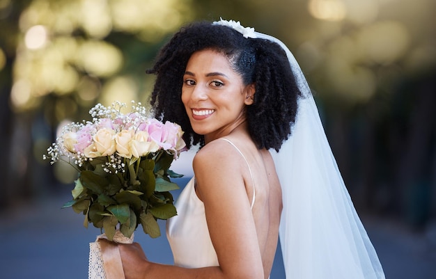 Cara de novia y mujer negra con boda y ramo de rosas felices en retrato con matrimonio y compromiso Celebración de eventos al aire libre y felicidad con sonrisa en el parque casada y moda de primavera